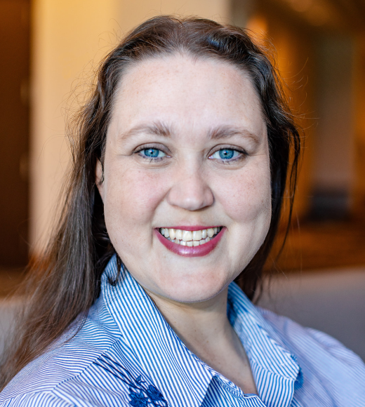 Woman in blue collared shirt with blurred background