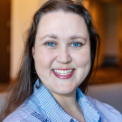 Woman in blue collared shirt with blurred background